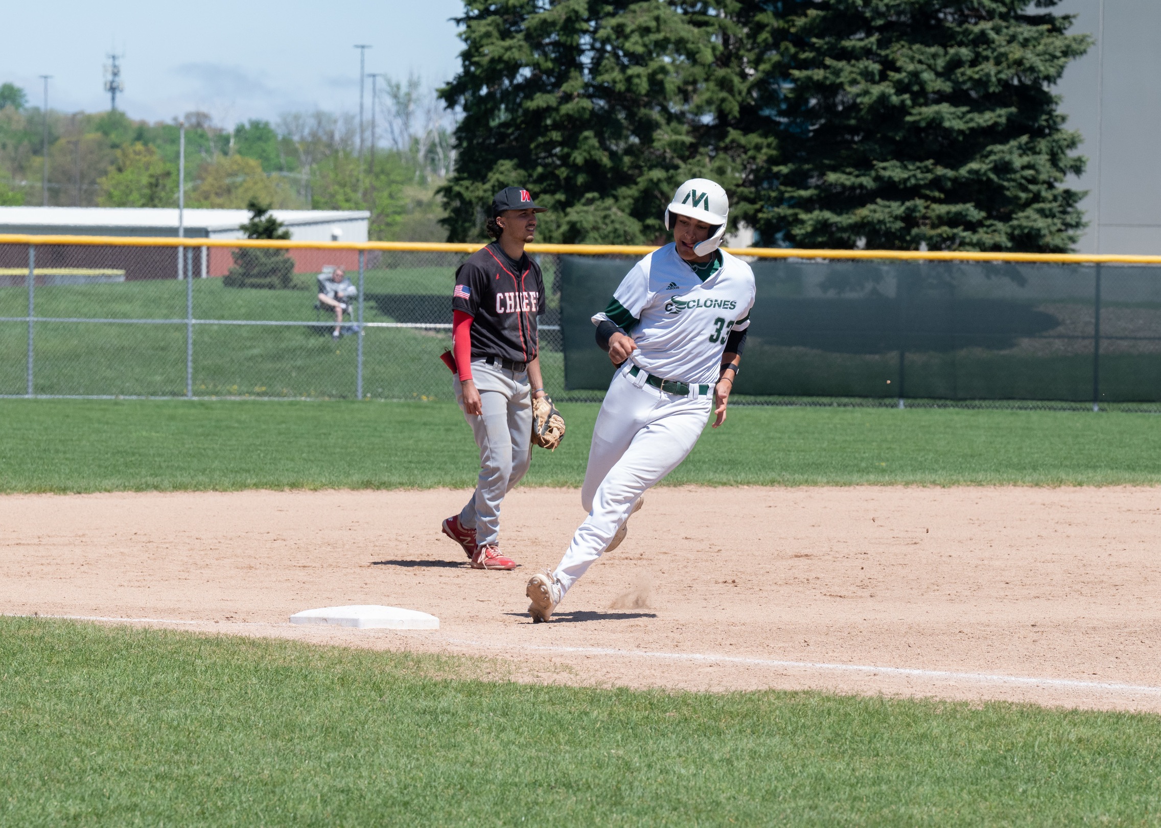 A baseball player rounding third base.