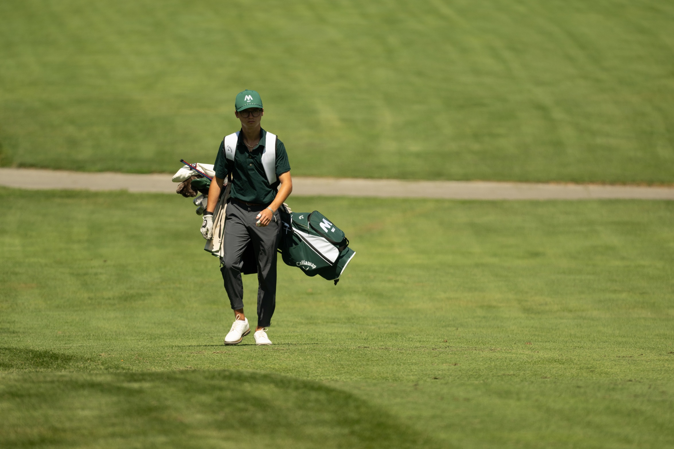 A Moraine Valley golfer carries his golf bag on the course.