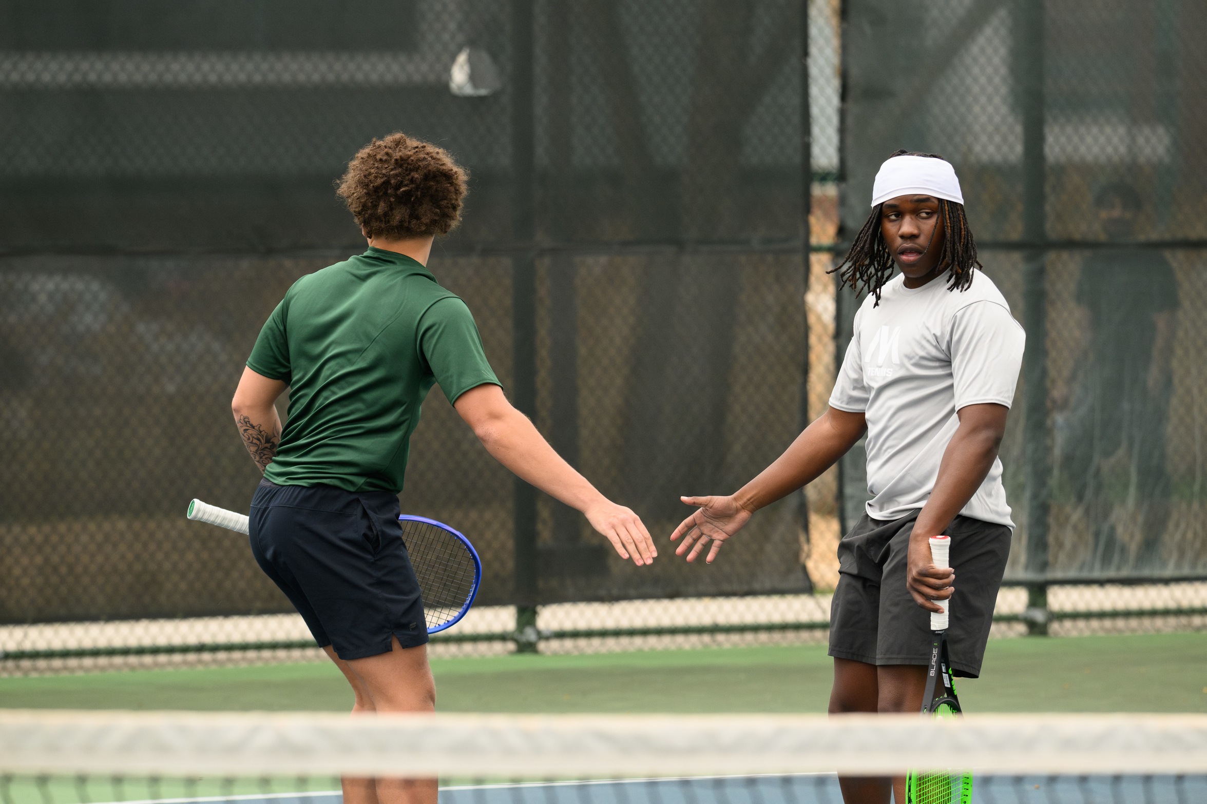 Two Moraine Valley tennis players high fiving each other.