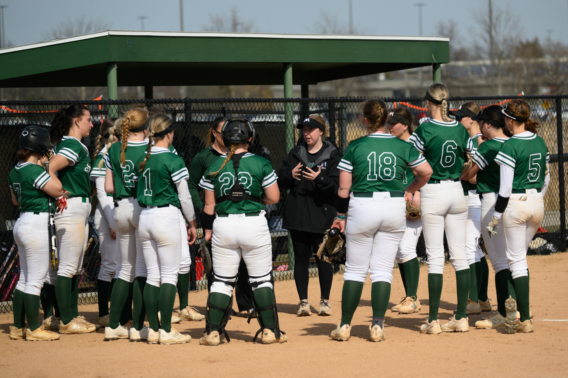 The Moraine Valley softball team in a huddle.